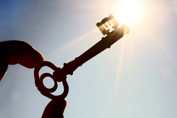 Geschäftsmann Hält Einen Schlüssel Auf Schönen Blauen Himmel Hintergrund — Stockfoto