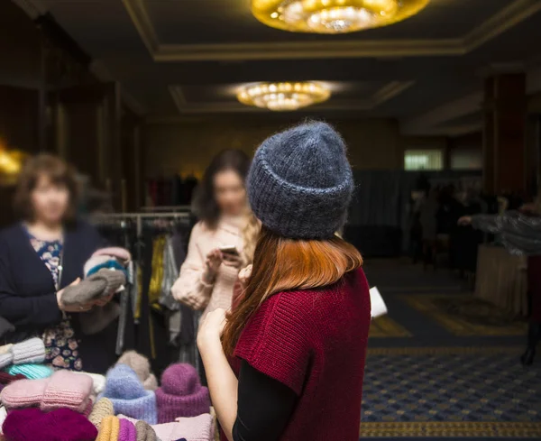 Молодая Рыжая Женщина Пытается Вязать Шляпу Магазине — стоковое фото