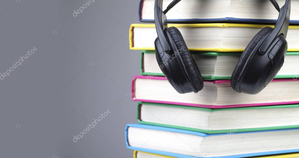 Books and headphones as audio books concept. isolated on grey background.