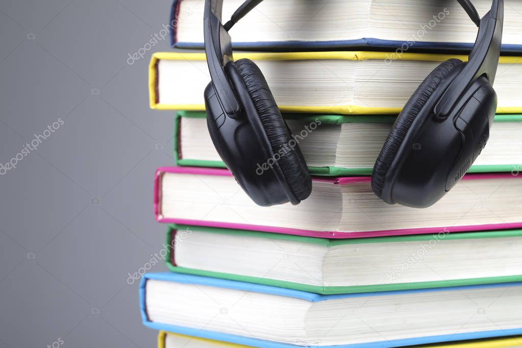 Books and headphones as audio books concept. isolated on grey background.