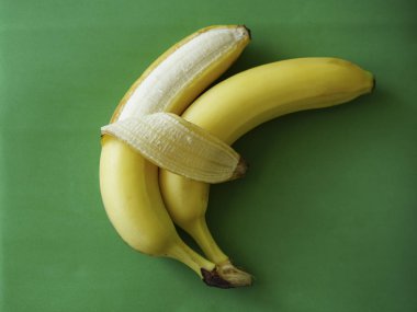 İki muz üzerinde yeşil arka plan izole. Sevgi ve hassasiyet. işaret, sembol, Çift kucaklayan kavramı