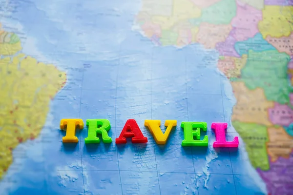 单词旅行是用五彩缤纷的字母写成的 世界地图背景 — 图库照片