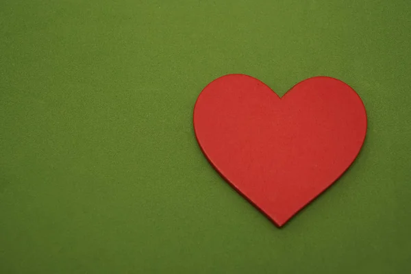 Jedno Serce Czerwone Leżą Zielone Tło Puste Miejsce Napis Szczęśliwych — Zdjęcie stockowe