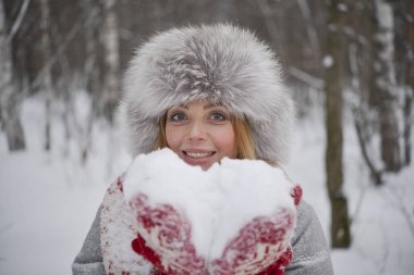 Kalp şeklinde kar. kar karlı kış ormanda üfleme kış kürk şapka neşeli sarışın kadın. Sevgililer günün kutlu olsun 