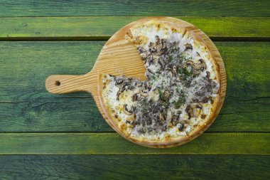 dilim pizza ahşap bir tepside. yeşil tablo üstten görünüm.