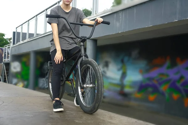 Legs and bmx bicycle on bmx park background.