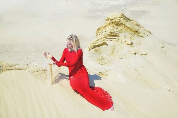 blond woman posing in red dress in desert 