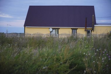 Rus köy yalnız ev, kasvetli mavi bulutlu gökyüzü.