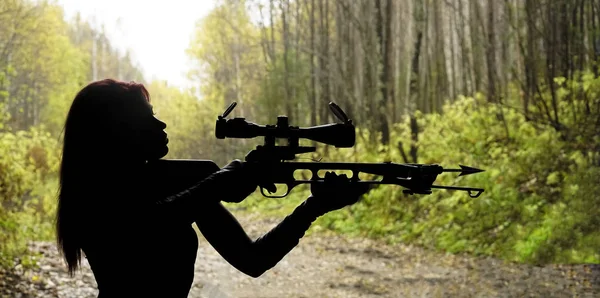 silhouette of woman shooting with bow and arrow.