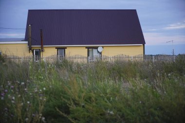 Tek başına evde bir kasvetli mavi bulutlu gökyüzü ile Rus köy.