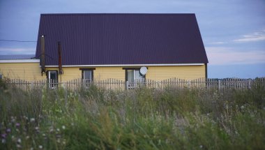 Tek başına evde bir kasvetli mavi bulutlu gökyüzü ile Rus köy.