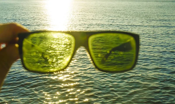 Male Hand Holding Stylish Sunglasses Sunset Sky Sunny Blue Water — Stock Photo, Image