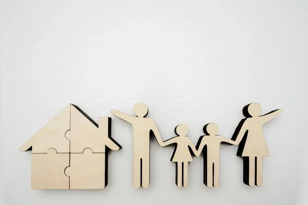 wooden sign of whole family and house made from wood four puzzle, jigsaw. wooden background.