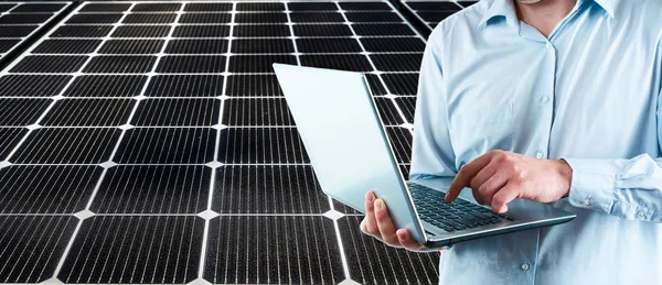 hand of engineer man typing text on laptop against solar power panel  background. Place for text. no face.