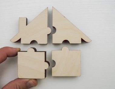  ahşap ev dört parçadan yapılmış - beyaz ahşap arka plan üzerinde bulmacalar. 