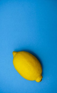 bir sarı mavi Kağıt arka plan üzerinde bütün limon 