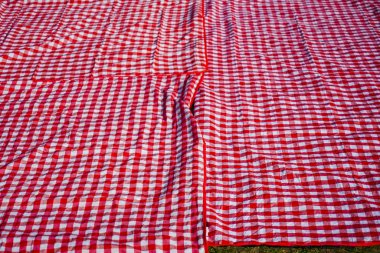 Kırmızı ve Beyaz şemsiye Plaidon yeşil çim zemin arka plan.