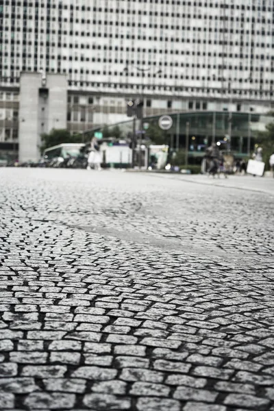 Historic stone cobbles in the antique city center on business office building background. Paving pedestrian walkway.