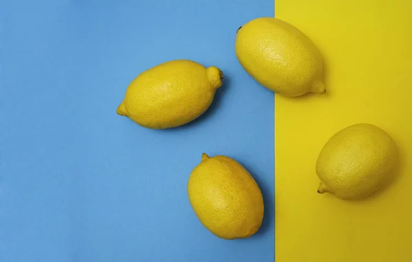 Cuatro Limones Amarillos Sobre Papel Amarillo Fondo Azul Antecedentes Alimentarios — Foto de Stock