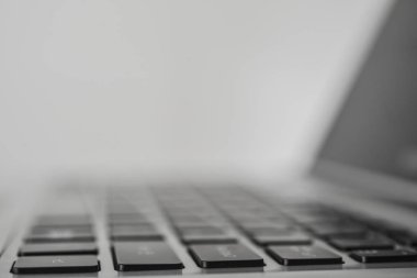 Açık beyaz dizüstü ekran üzerinde klavye yansıması ile. gri arka plan. Seçici odak. Yan görünüm.