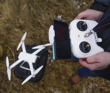Uzaktan kumanda quadcopter işleme adam. Çalışma Drone'un uzaktan kumanda dostum. üstten görünüm. kış sezonu. 