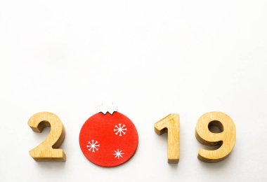 Sayı 2019, Noel kırmızı topu ile dekore edilmiş ahşap sayıların oluşur. Noel kompozisyon, 2019 mutlu yeni yıl. Beyaz arka plan üzerinde izole.  
