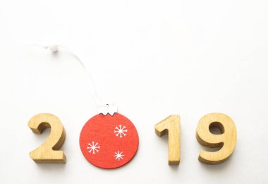 Sayı 2019, Noel kırmızı topu ile dekore edilmiş ahşap sayıların oluşur. Noel kompozisyon, 2019 mutlu yeni yıl. Beyaz arka plan üzerinde izole.  