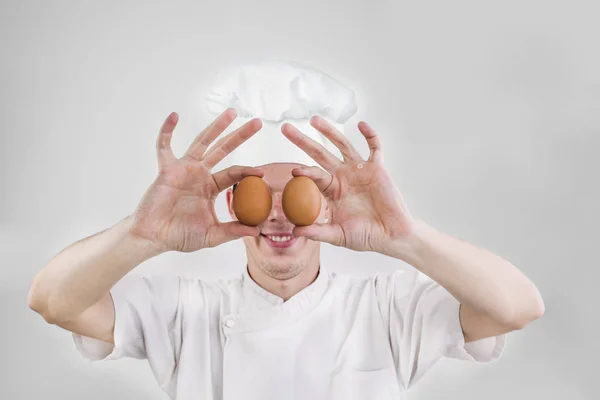 Sonriente Cara Hombre Guapo Uniforme Cocinero Sosteniendo Dos Huevos Delante — Foto de Stock