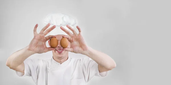 Sonriente Cara Hombre Guapo Uniforme Cocinero Sosteniendo Dos Huevos Delante — Foto de Stock