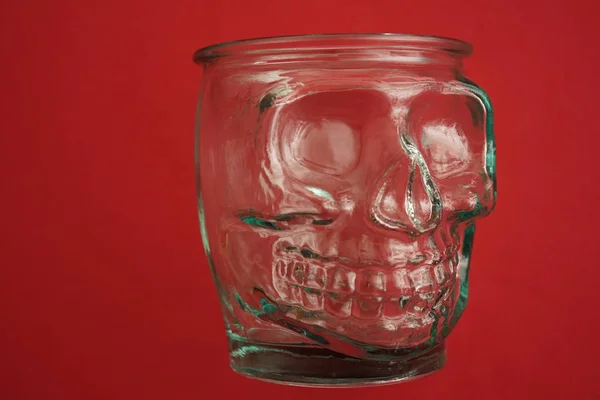 Leeres Glas Form Eines Menschlichen Schädels Isoliert Auf Rotem Hintergrund — Stockfoto