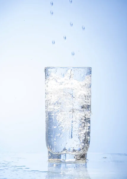 Salpicaduras Agua Vaso Aislado Sobre Fondo Blanco Azul —  Fotos de Stock