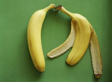 Bütün muz ve yeşil zemin üzerine sarı kabuğu. 