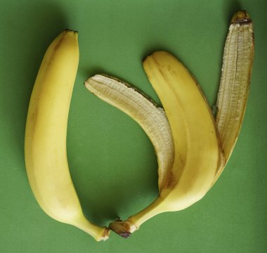 Bütün muz ve yeşil zemin üzerine sarı kabuğu. 