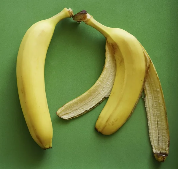 全体のバナナと緑の背景に黄色の皮 — ストック写真