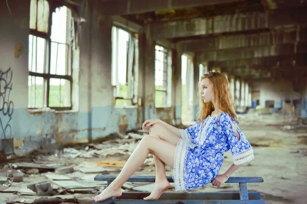 一幅年轻哭泣的女孩坐在蓝色木桌上的画像 坐在废弃的室内 孤独的概念 唯一的朋友 — 图库照片