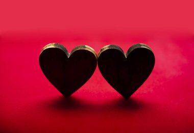 iki ahşap kalp kırmızı zemin üzerine izole. mutlu sevgililer günü.