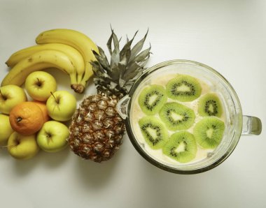 Beyaz masada meyve sıkacağı veya blender organik meyve karıştırma. üst görünüm 