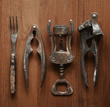 Corkscrew ile mutfak araçları yığını, sarımsak basın, çatal, ahşap masa arka planda Fındıkkıran. boş kopya alanı