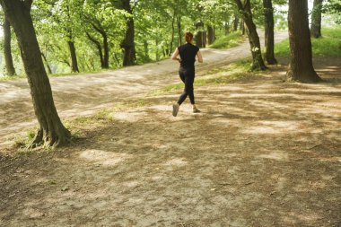 Güzel yaz günlerinde güneş parkında kadın koşu.