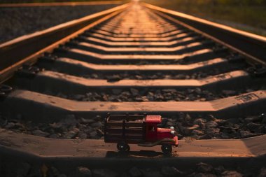 perspektifte demiryolu. gün batımı ışığı. ahşap kamyon - oyuncak beton yataklı standı. lojistik iş fikri