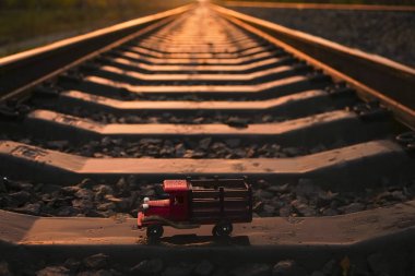 perspektifte demiryolu. gün batımı ışığı. ahşap kamyon - oyuncak beton yataklı standı. lojistik iş fikri