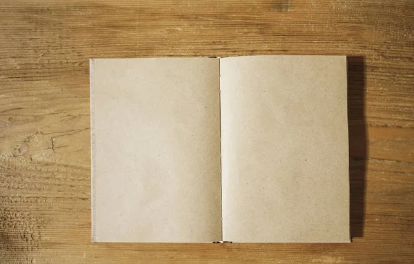 白い木製のテーブルの背景 トップビューに茶色のノートブックを開きます クラフトペーパー 碑文用の空のコピースペース — ストック写真