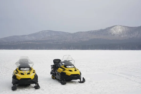 Δύο Κίτρινα Οχήματα Χιονιού Που Στέκονται Στον Πάγο Ενάντια Στα — Φωτογραφία Αρχείου