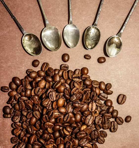 コーヒー豆の周りの多くのビンテージ スプーン 茶色の背景に分離 — ストック写真