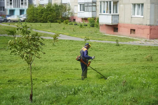 园丁割草的工人 那个穿着普通工人制服在草坪上干活的人 — 图库照片