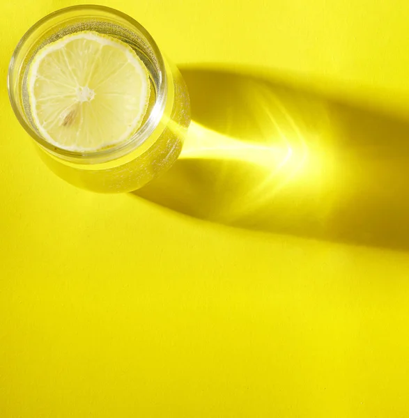 Vaso Con Rodaja Limón Vista Superior Sombra Sobre Fondo Amarillo — Foto de Stock