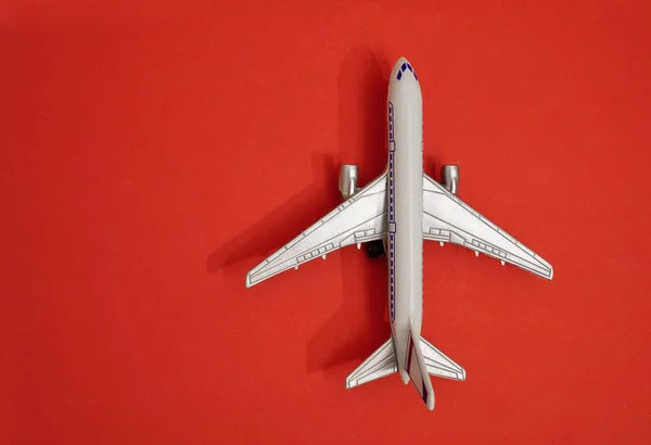 金属製のおもちゃ 赤い紙の背景に飛行機 旅行と交通のアイデア — ストック写真