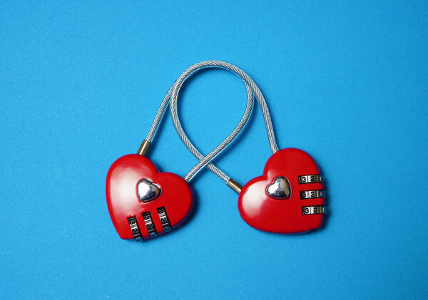 Два замка связаны друг с другом в виде сердец, изолированных на синем фоне. 14 февраля - С Днем Святого Валентина
. 