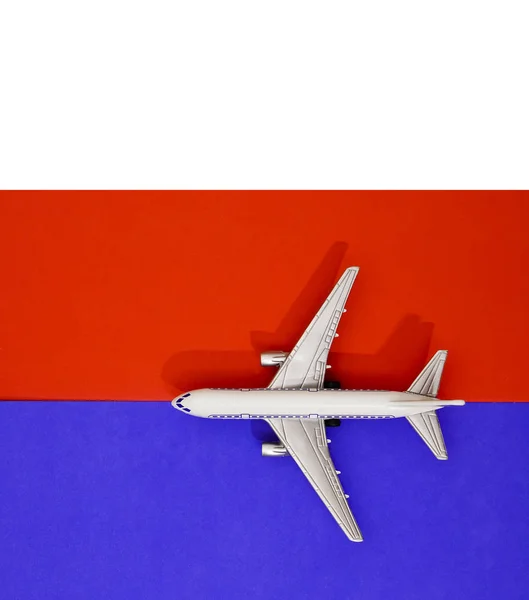 金属製のおもちゃ 赤と青の紙の背景に飛行機 旅行と交通のアイデア — ストック写真