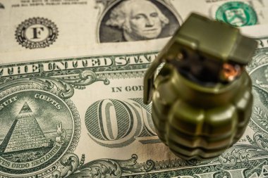 Amerikan doları banknotlarının arka planına karşı bir çek ile El Bombası.
